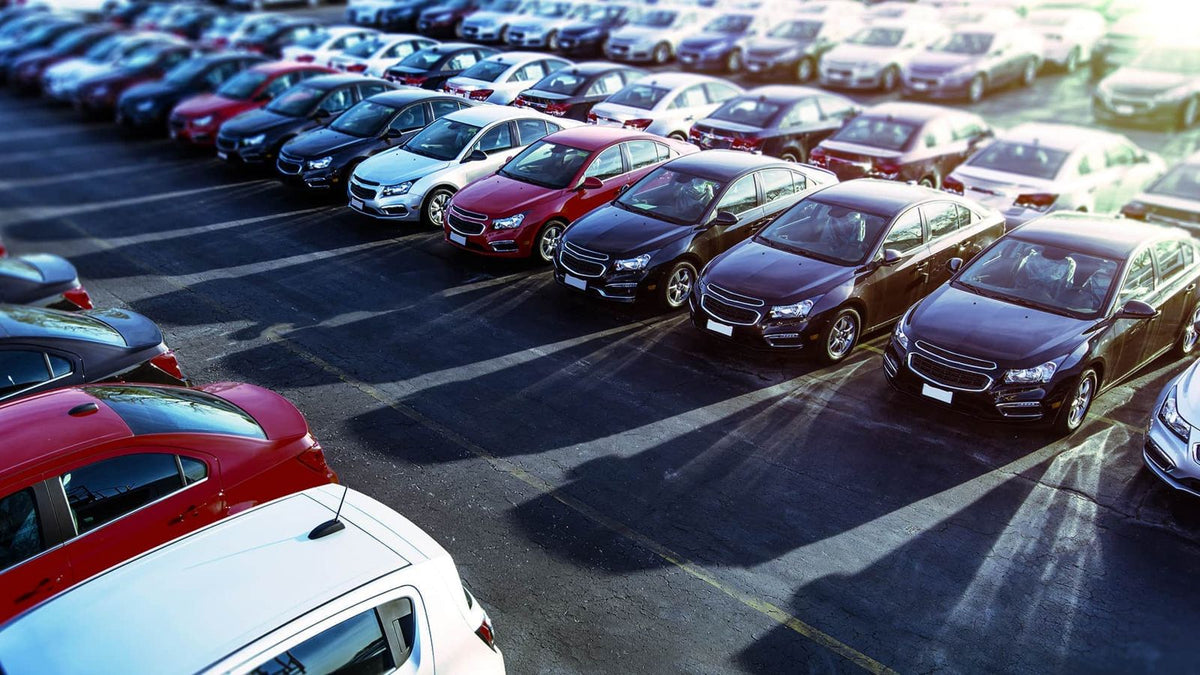 Car dealership lot with rows of new and used cars - auto dealership insurance
